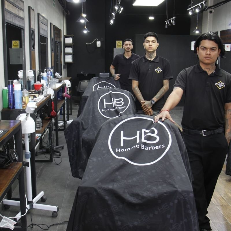 Barberos expertos listos para ofrecer servicios premium en Homme Barbers Cancún.